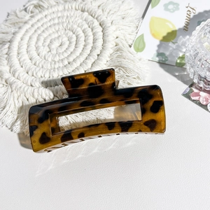 Close-up of leopard print rectangular hair claw clip with cutout geometric design
