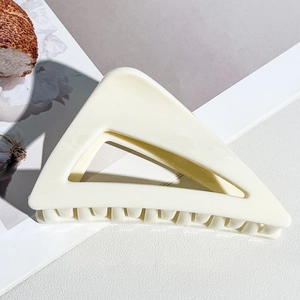 Détail d'une grande pince à cheveux triangle crème ivoire au fini brillant