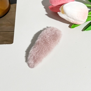 Macro shot of soft plush velvet hairband in dusty pink on white leather background