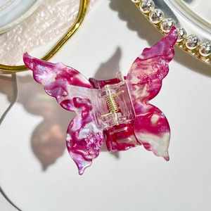 Close-up of pink marble butterfly hair claw clip with silver glitter and pearl accents