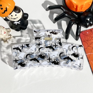 Detail view of square Halloween claw clip with ghost and black cat prints on acrylic