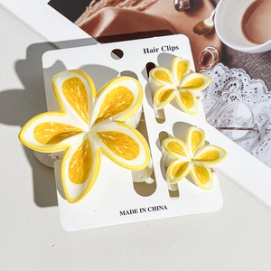 Close-up of lemon print flower hair clips set including one large and two small claw clips