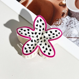 Detail of flower hair claw clip with dragon fruit pattern on fashionable magazine background