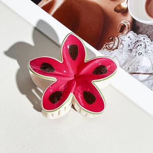 Detail view of flower-shaped hair claw clip with watermelon print and green borders