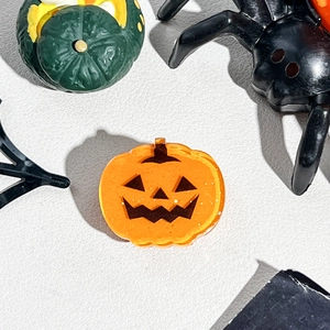 Macro shot of an orange acrylic pumpkin hair claw with glitter for Halloween accessory