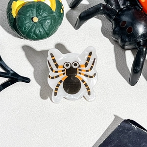 Macro view of cute acrylic cartoon spider hair clip with black body and big eyes