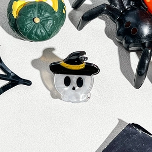 Macro detail of a mini Halloween acrylic hair clip featuring a skull with a black wizard hat