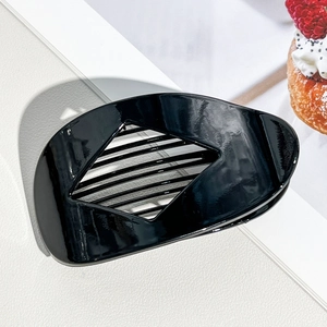 Close-up of black glossy hair claw clip with geometric hollow and inner teeth design