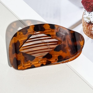 Detail of tortoiseshell leopard print hair claw clip showing internal teeth and curved structure