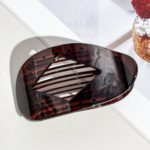 Detail view of tortoiseshell acetate hair claw with hollow rhombus design and inner teeth