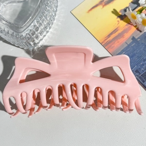 Close-up of a large pink matte hair claw clip with a strong metal spring and square design