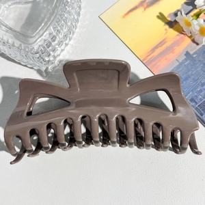 Detailed close-up of dark brown large hair claw clip with glossy finish and strong teeth