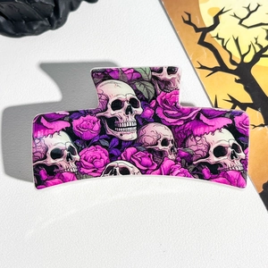 Detail of square hair claw clip featuring gothic skull and rose floral print on white leather