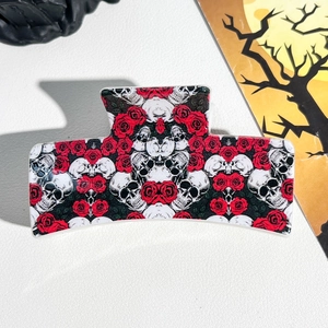 Detail of Halloween hair claw clip showing gothic skull and red rose floral pattern prints