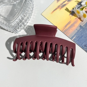 Close-up of the large matte burgundy shark hair claw clip with strong grip and fine texture