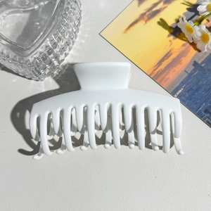 Close-up of a large white matte hair claw clip with strong teeth for thick hair styling