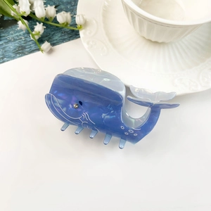 Dettaglio del fermaglio a balena blu con trama marmorea e occhio in strass scintillante