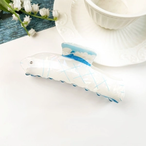 Dettaglio della molletta per capelli a delfino con onde blu e strass decorativo