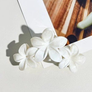 Vue détaillée de la pince à cheveux fleur de frangipanier avec texture marbrée