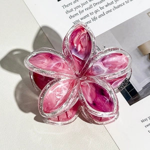 Dettaglio del fermaglio per capelli in resina marmorizzata rosa con bordi glitterati