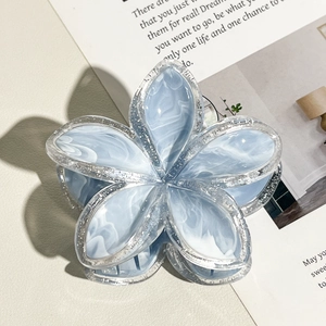 Dettaglio molletta per capelli a fiore marmorizzato blu con bordi glitterati e finitura lucida