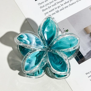 Dettaglio della pinza per capelli frangipani blu marmorizzata con bordi glitterati