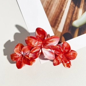 Détail d'une grande pince à cheveux de 11cm avec motif floral marbré rouge et blanc