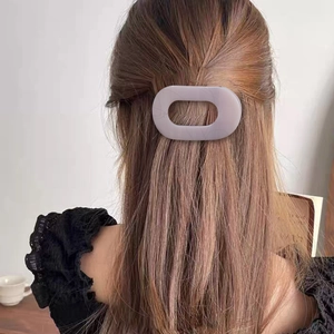 Pince à cheveux ovale plate violet mat sur les longs cheveux d'un modèle pour le style