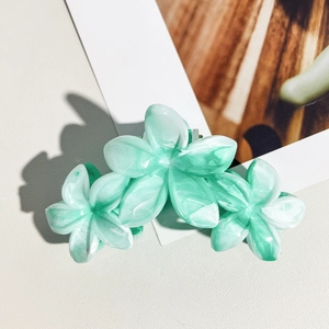 Vue détaillée de trois pinces à cheveux en marbre vert en forme de fleur de frangipanier
