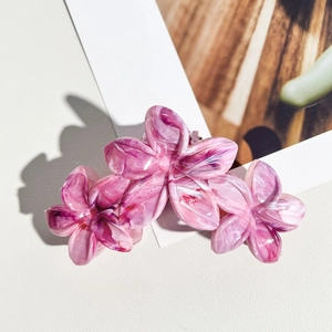 Détail macro d'une pince à cheveux de 11cm avec motif marbré violet et fleurs