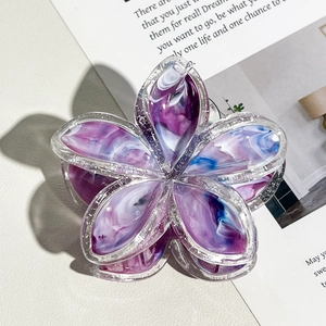 Dettaglio della molletta per capelli a fiore con trama marmorea viola e bordi glitter