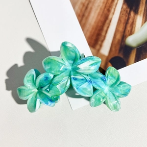 Vue détaillée de la pince à cheveux 11cm à motif marbré vert sur un support en bois