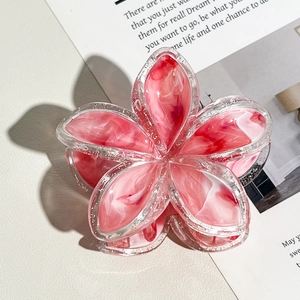 Dettaglio della molletta frangipane con petali in marmo rosa e accenti glitterati argento