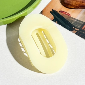 Détail de la pince à cheveux ovale jaune crème avec dents intérieures à forte prise