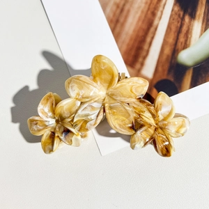 Détail de la pince à cheveux frangipanier 11cm avec texture marbrée et fini ambré