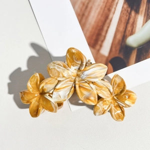Détail de la pince à cheveux triple frangipanier avec texture marbrée jaune et blanche