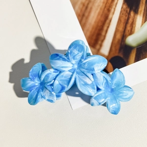 Détail de la pince à cheveux de 11 cm motif marbre bleu et blanc en forme de frangipanier
