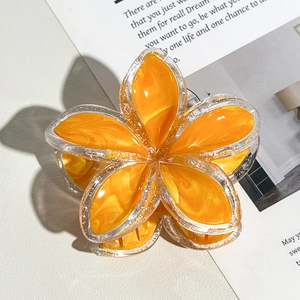 Dettaglio della pinza per capelli a forma di frangipani arancione effetto marmo