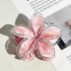 Dettaglio ravvicinato della molletta a fiore in resina rosa marmorizzata con glitter