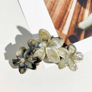 Détail de la pince à cheveux en acétate de 11cm avec texture marbrée et motif fleurs de lys