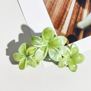 Macro de la pince à cheveux à motif marbré vert avec un design de trois fleurs