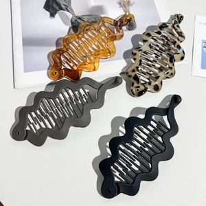 Detail of banana hair clips in amber, leopard, grey and black colors with wavy edges