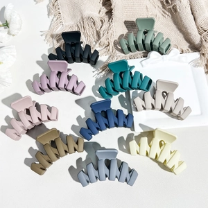 Flat lay of ten matte Morandi color hair claw clips in various elegant pastel shades