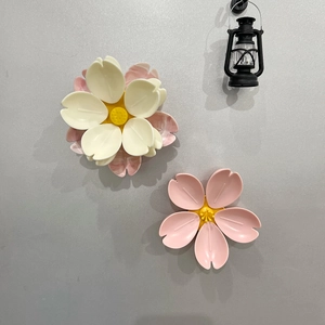 Macro detail of 3D cherry blossom magnetic clips with realistic pink resin petals