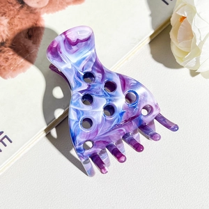 Detail of blue and purple marble pattern hair claw clip with acetate glossy finish