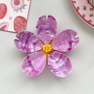 Close-up of a 3D cherry blossom magnet with purple marble texture and yellow stamen