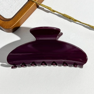 Deep purple glossy semi-circular claw clip for hair styling on minimalist white background