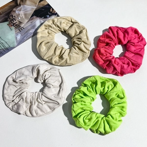 Detail view of large ribbed fabric scrunchies in khaki, rose, light grey and bright green