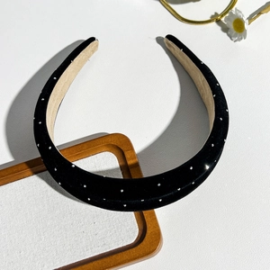 Detail of black suede headband with silver rhinestones and soft beige inner lining