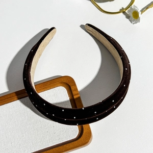Detailed texture of dark coffee suede headband with sparkling rhinestones and beige lining